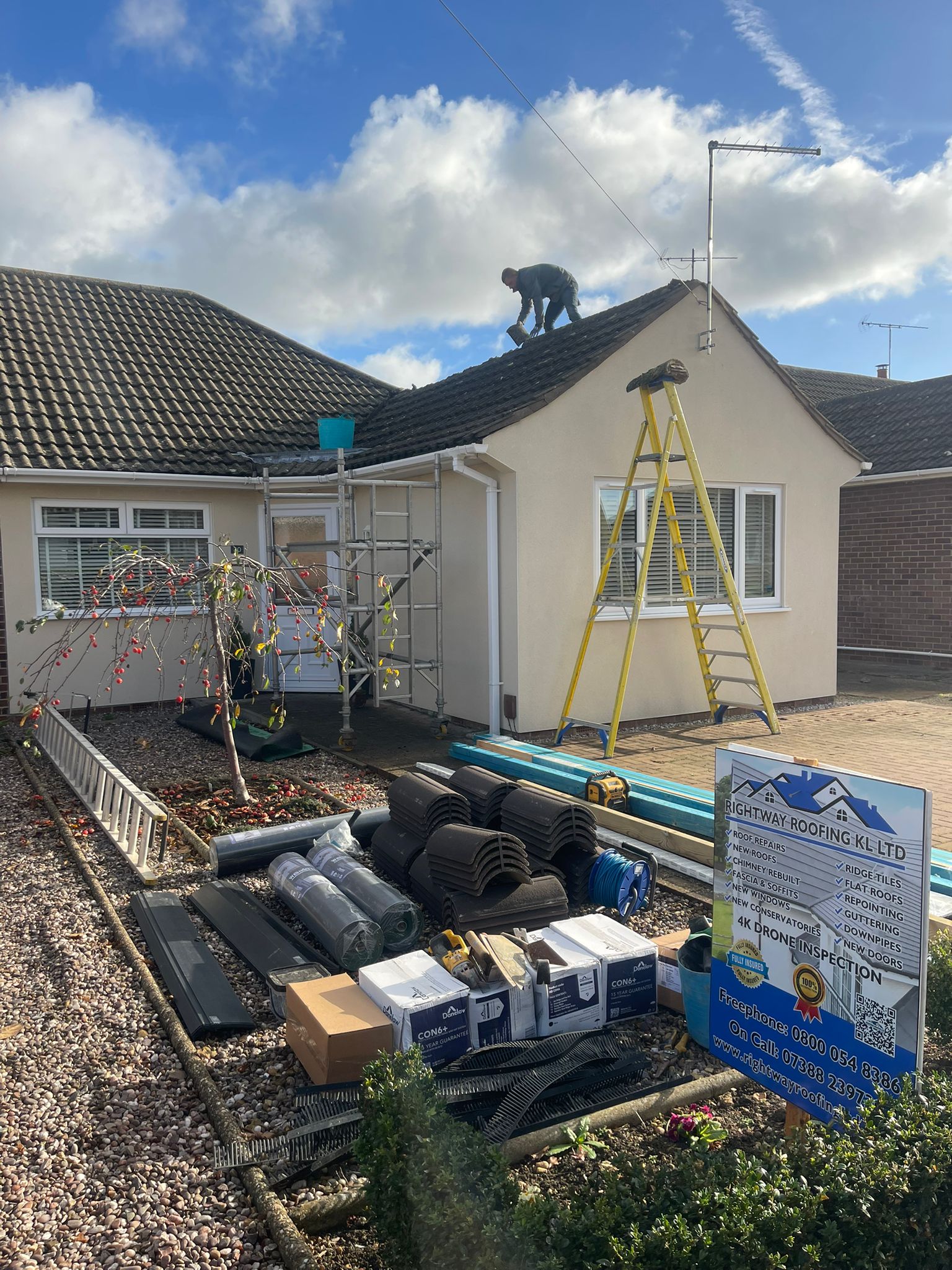 Professional setup with company signage and roofing materials on site