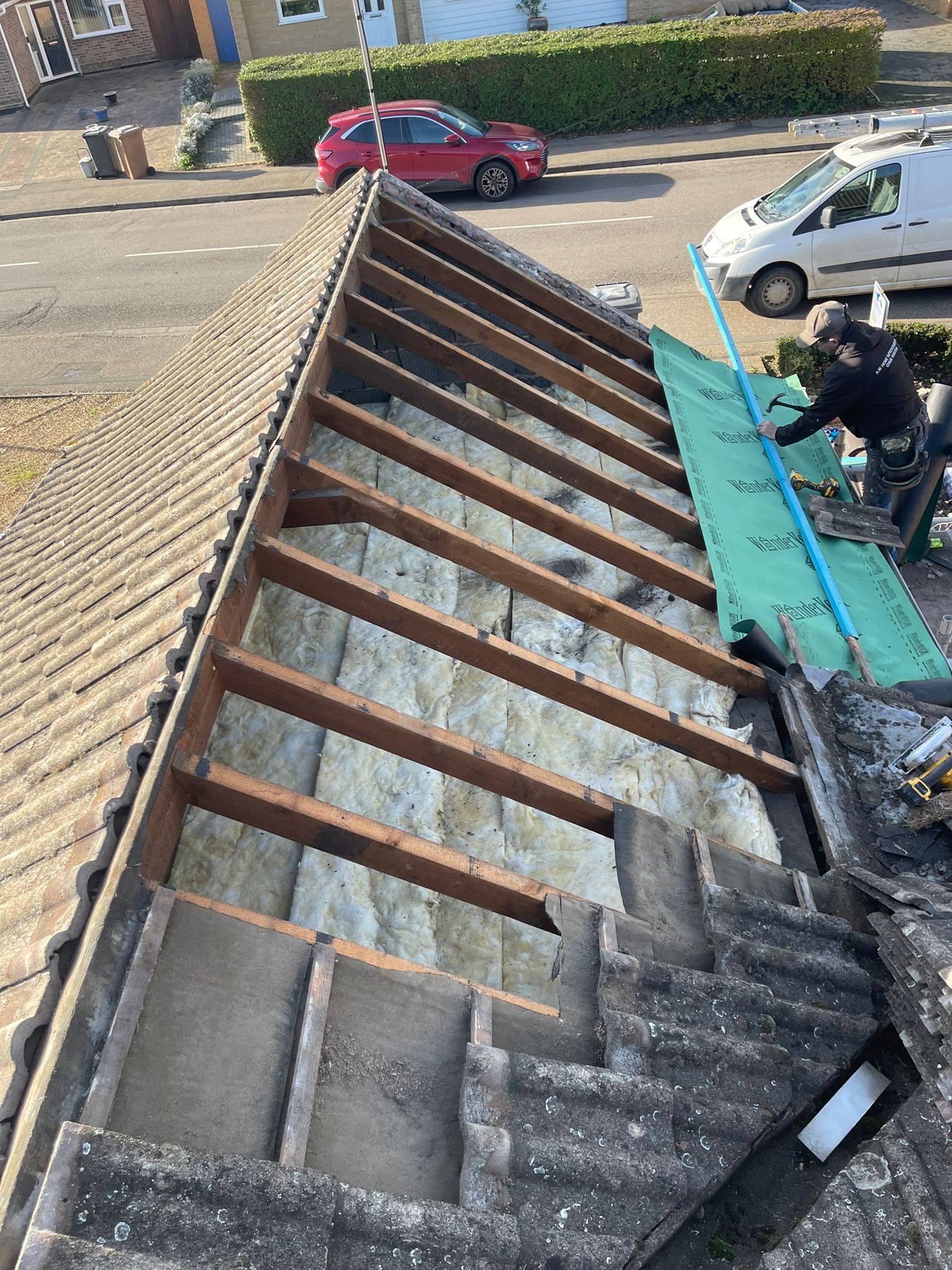 Exposed roof structure showing beams and insulation during major repair